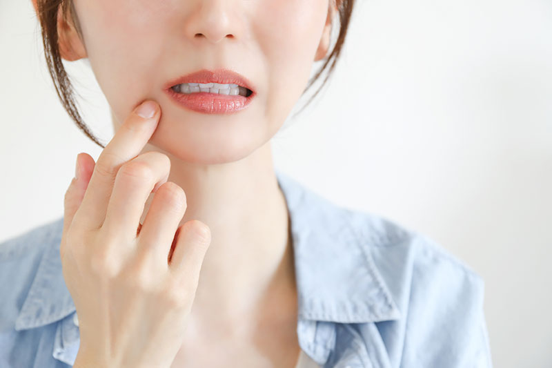 口元を抑える女性